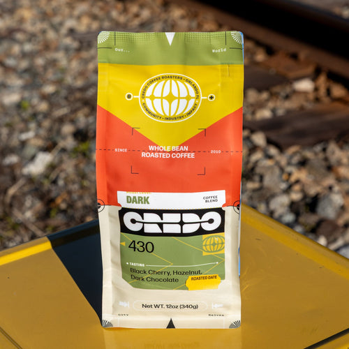 Credo coffee package on a yellow surface with train tracks in the background
