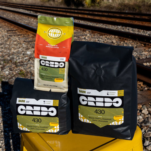 Credo coffee bags on a yellow stool with train tracks in the background
