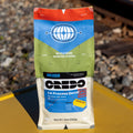 CREDO coffee bag on a yellow surface with train tracks in the background