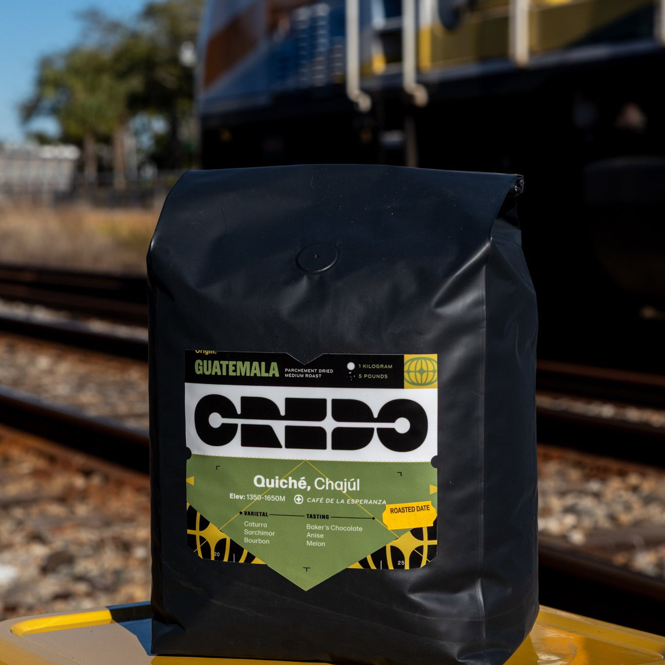 CREDO Guatemala coffee bag on a yellow surface with a train in the background