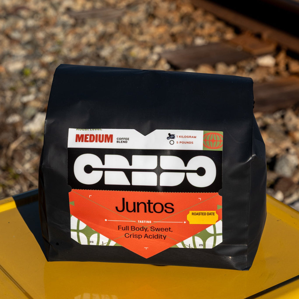 CREDO Coffee package on a yellow surface with train tracks in the background