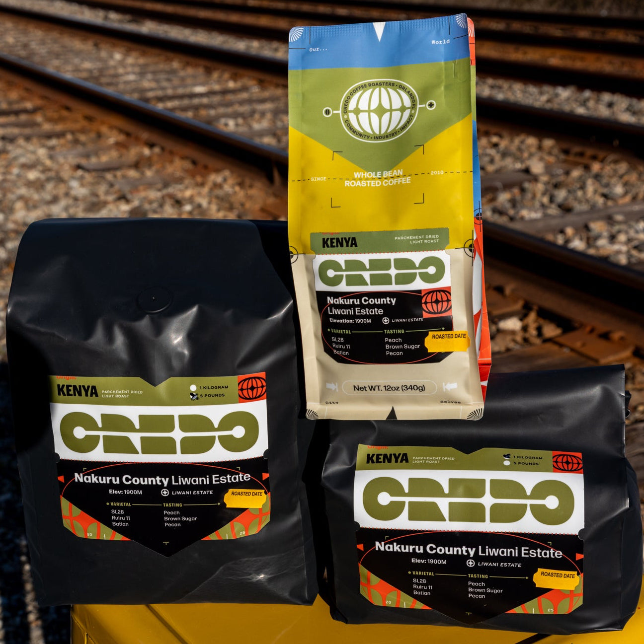 CREDO coffee packages on a yellow stool with train tracks in the background