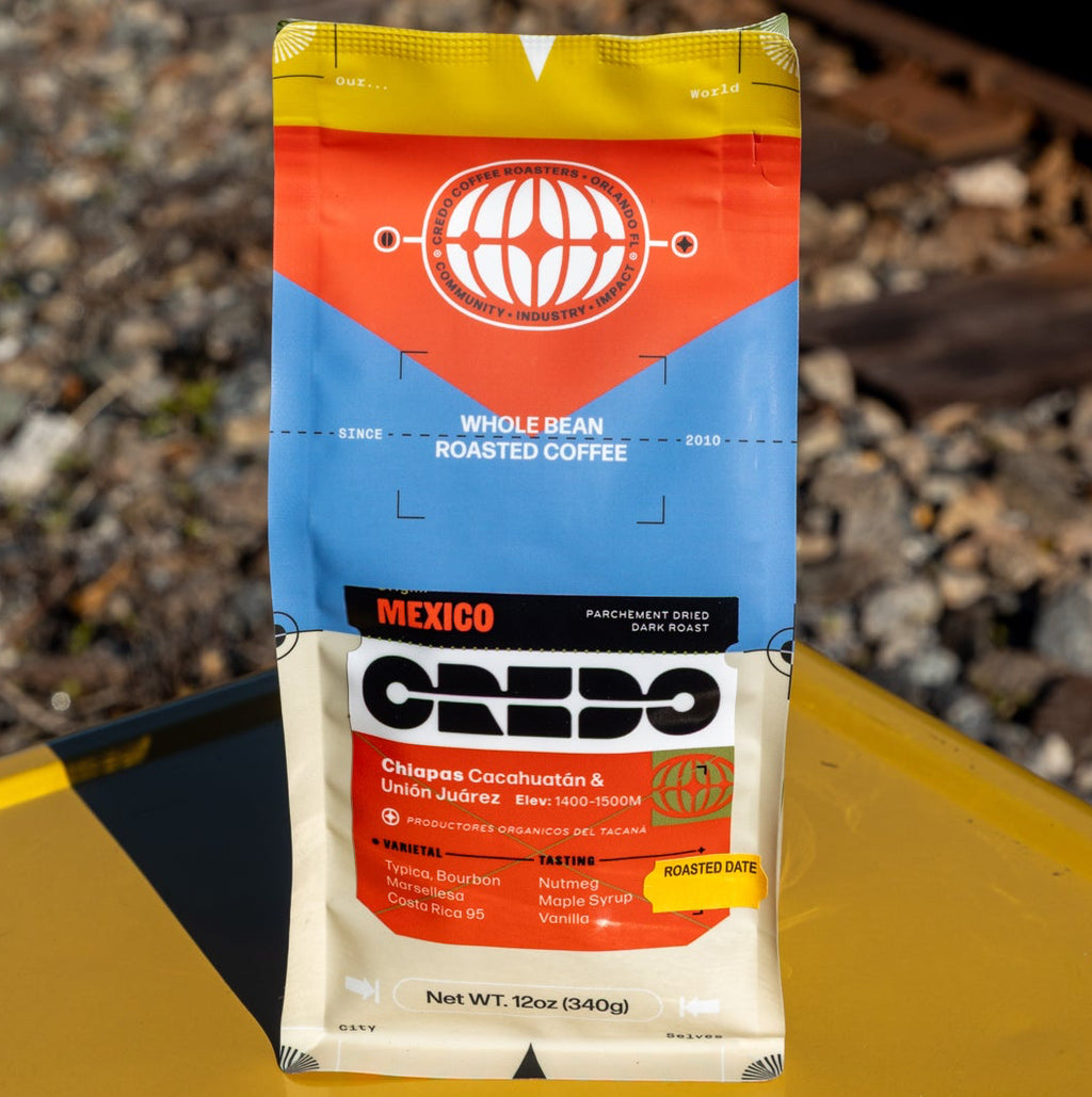 Credo coffee package on a yellow surface with train tracks in the background