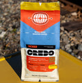 Credo coffee package on a yellow surface with train tracks in the background