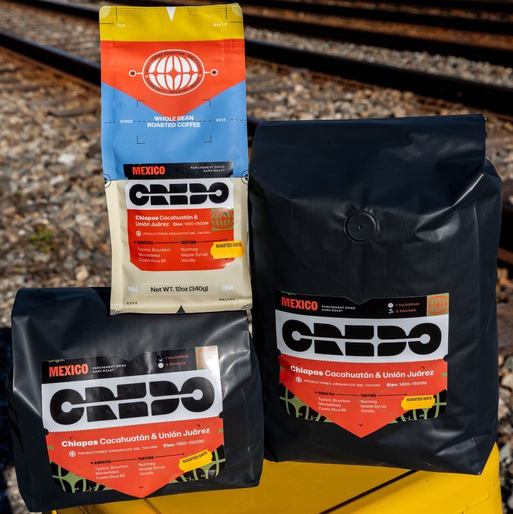Credo coffee bags on a yellow stool with train tracks in the background